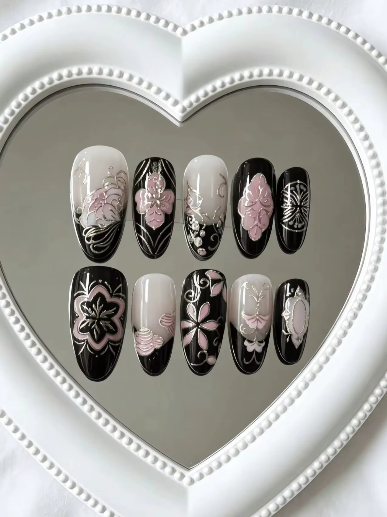 10 faux ongles en forme d'amande de longueur moyenne, coloris noir et nude avec motifs floraux roses