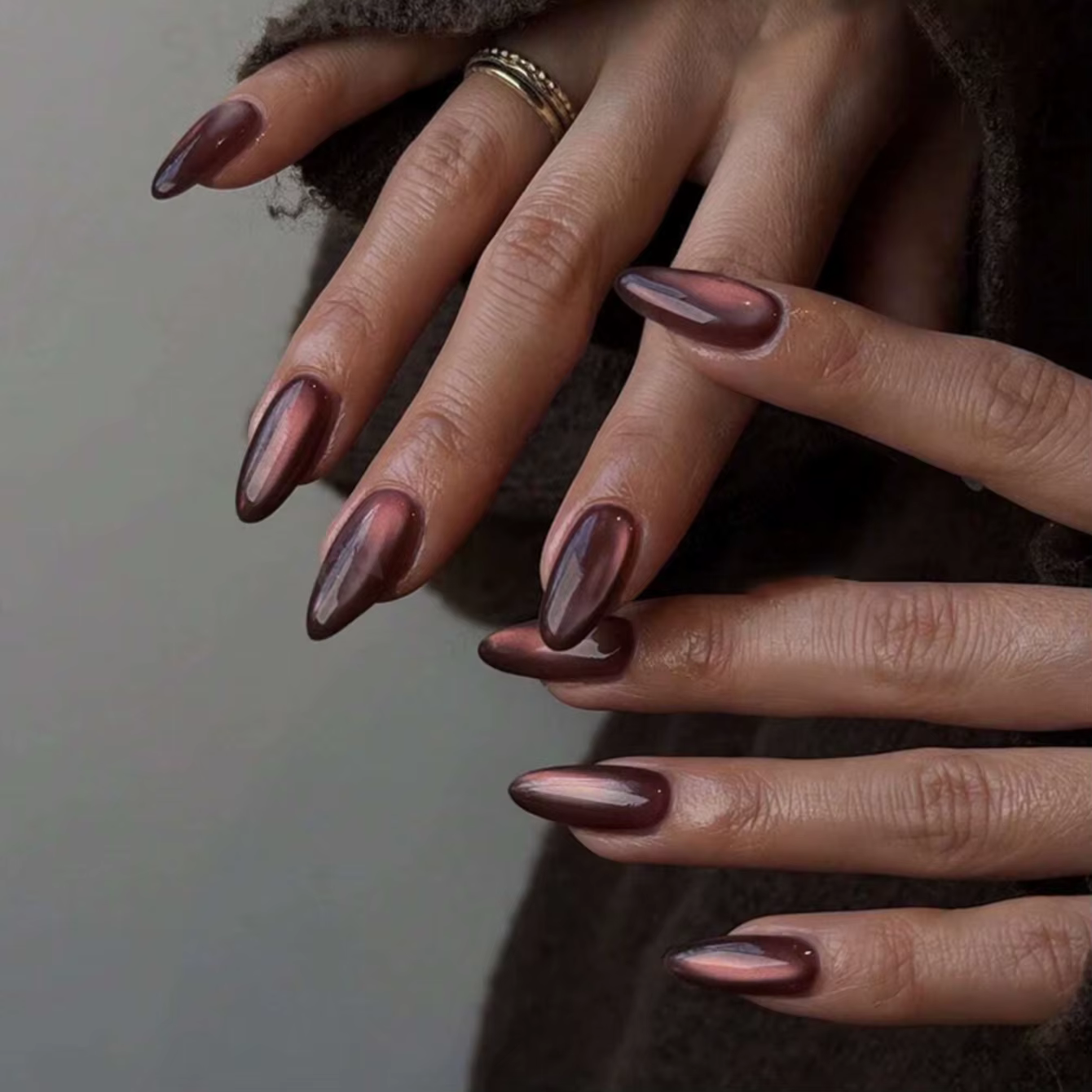 Ongles en amande faits à la main avec un effet œil-de-chat bordeaux profond, une subtile brillance m