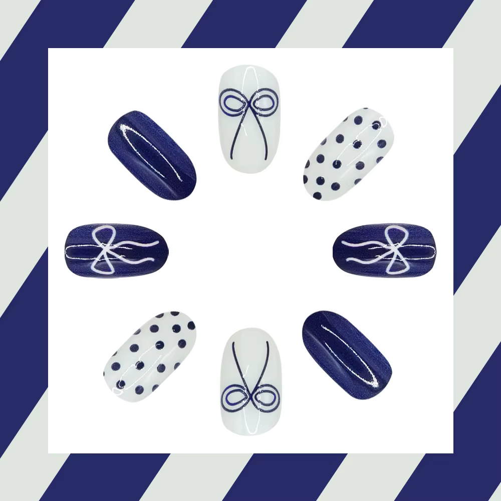 Faux ongles courts arrondis bleu profond avec papillon à pois