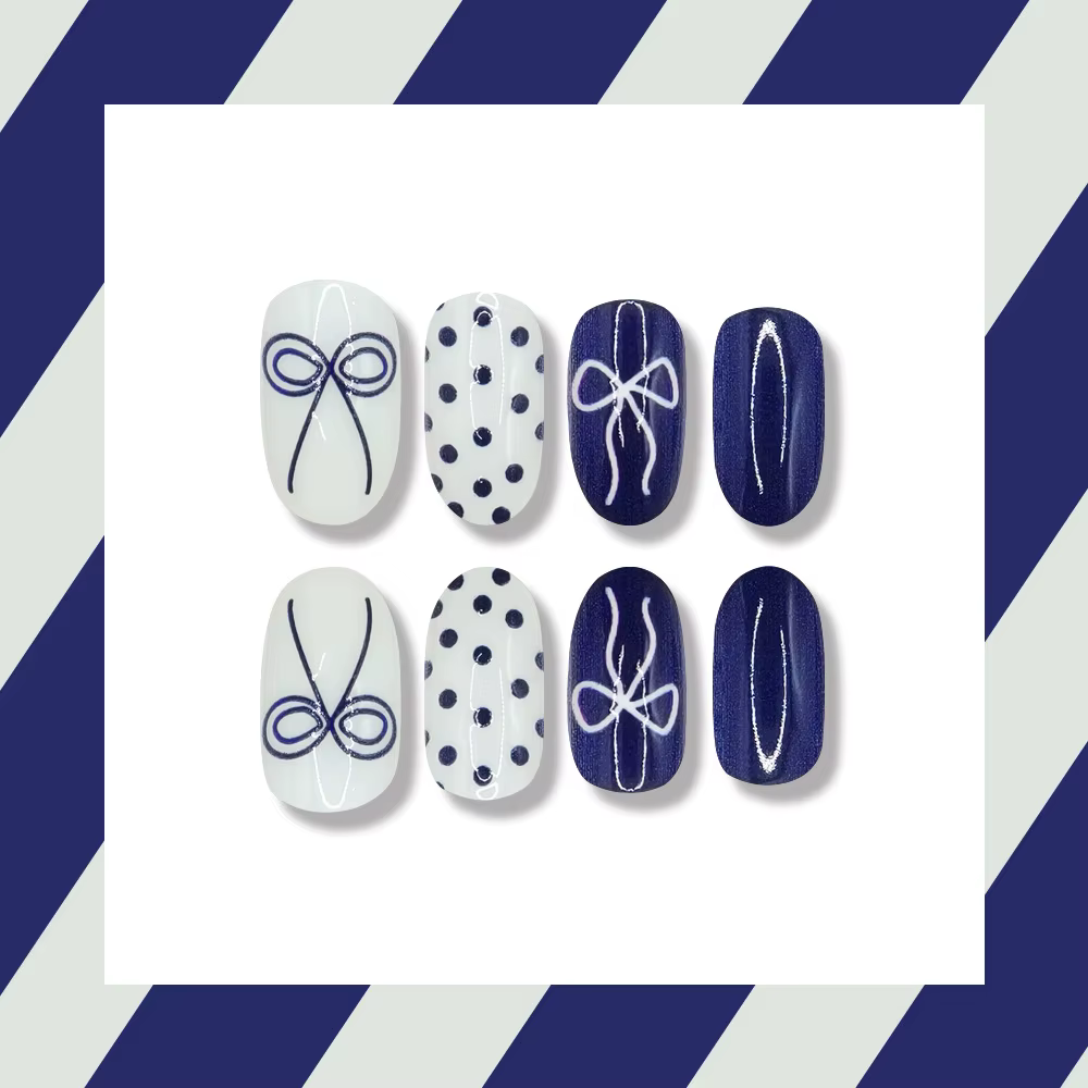 Faux ongles courts arrondis bleu profond avec papillon à pois