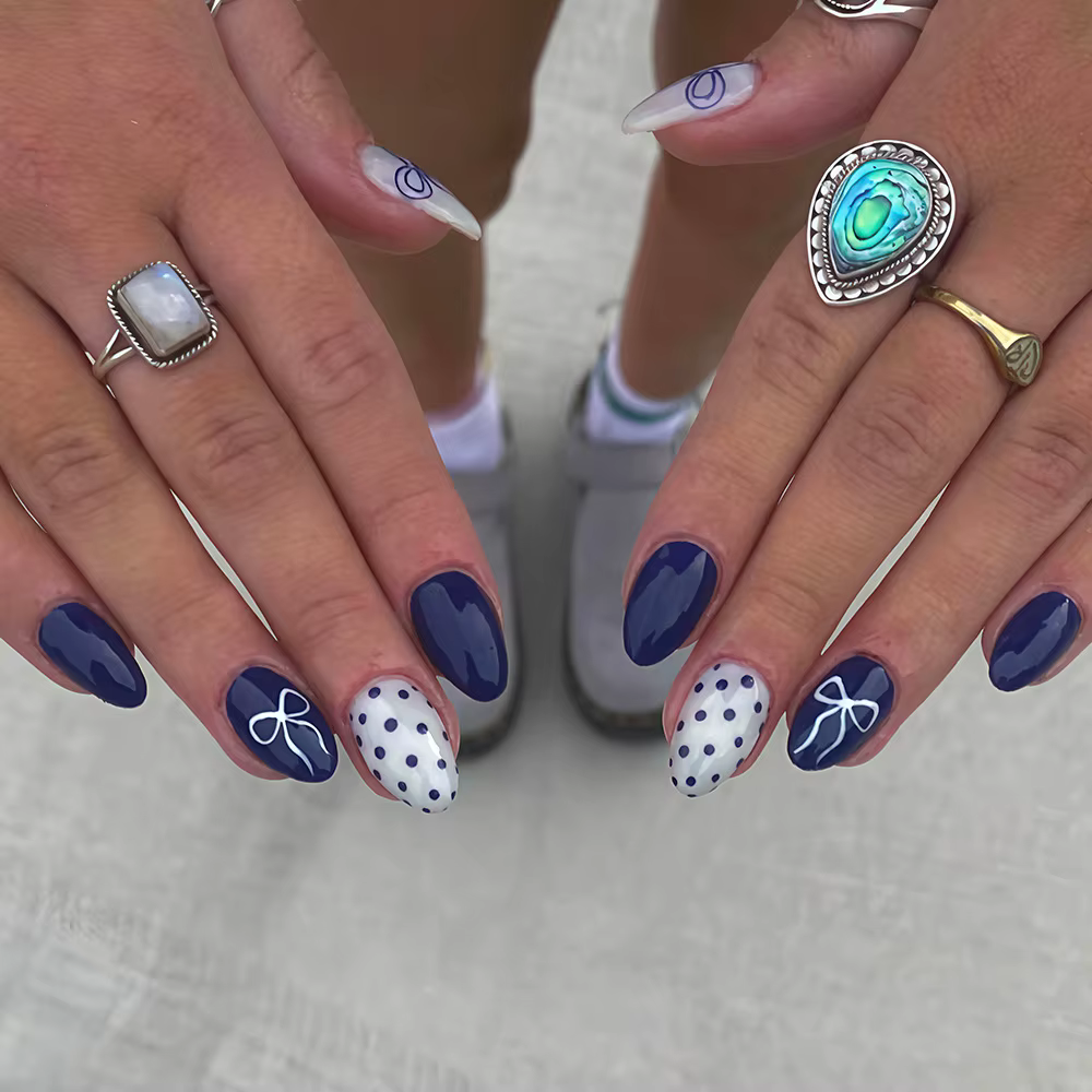 Faux ongles courts arrondis bleu profond avec papillon à pois