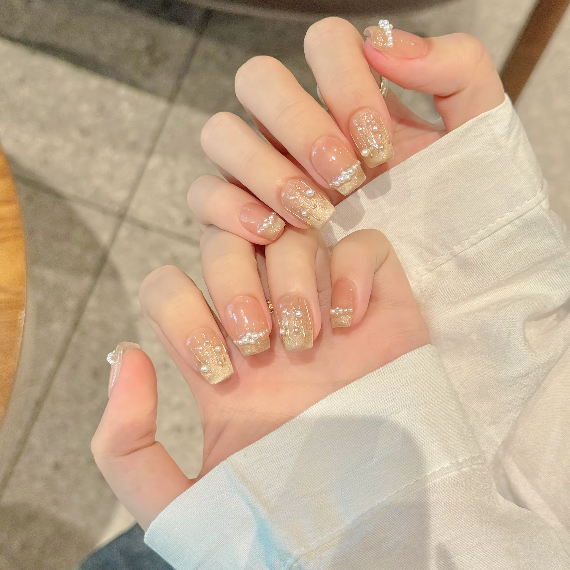 Presse à la main sur les ongles paillettes blanc perle décor faux