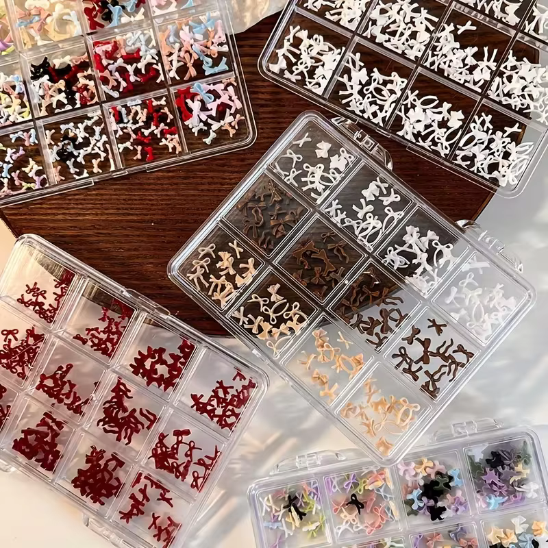 Une boîte de 12 accessoires d'art d'ongle à nœud coloré et doux