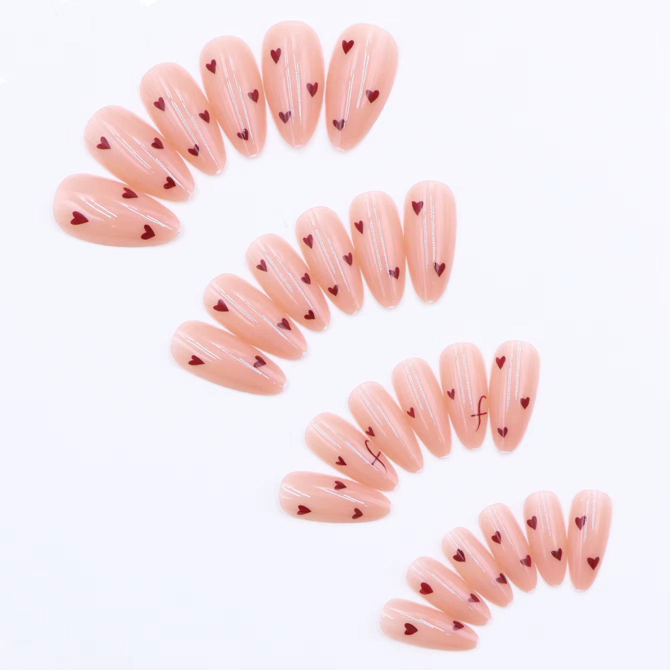 24 faux ongles en acrylique français pressés avec des motifs en forme de cœur et de lettres.