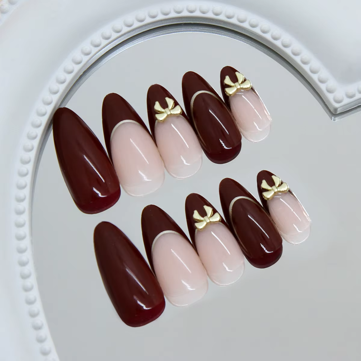 24 ongles d'amande faits à la main. Base bordeaux avec détails français nude