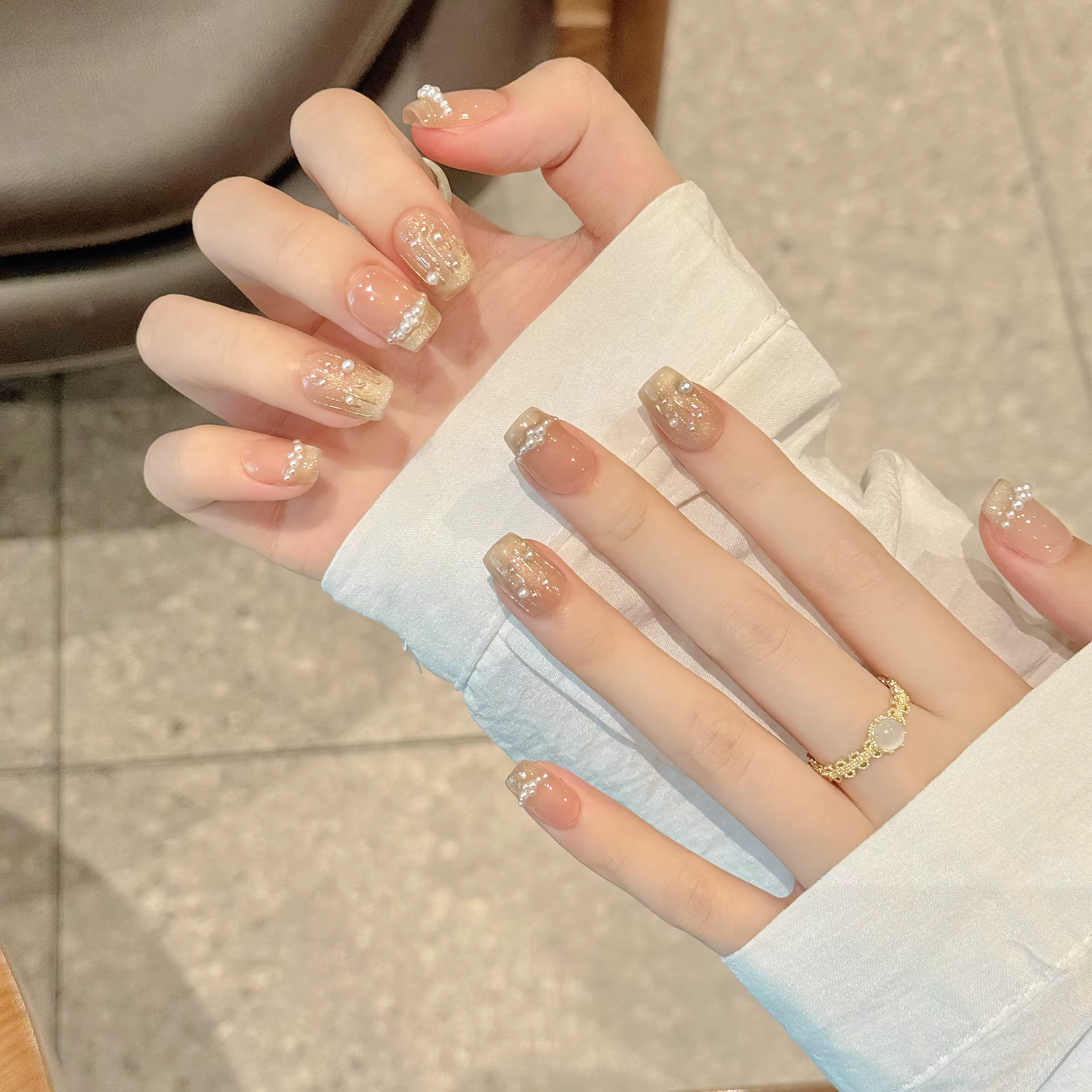 Presse à la main sur les ongles paillettes blanc perle décor faux