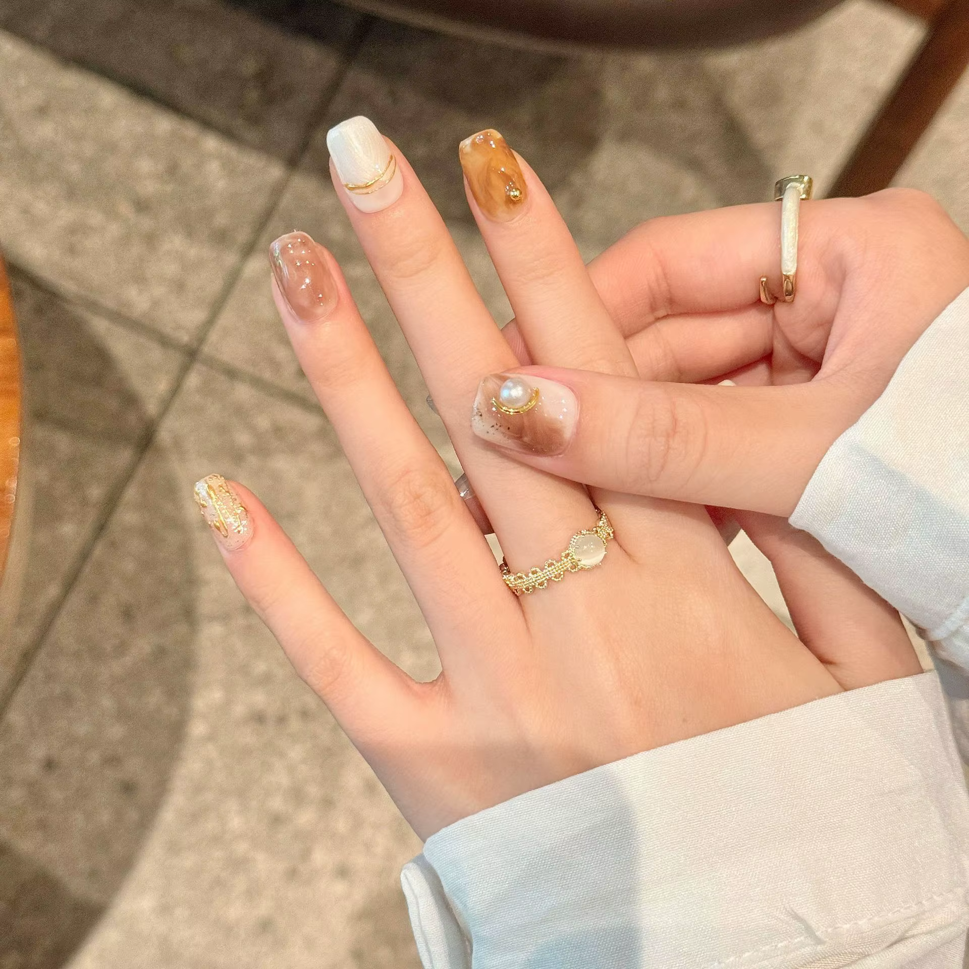Presse à la main sur les ongles paillettes blanc perle décor faux