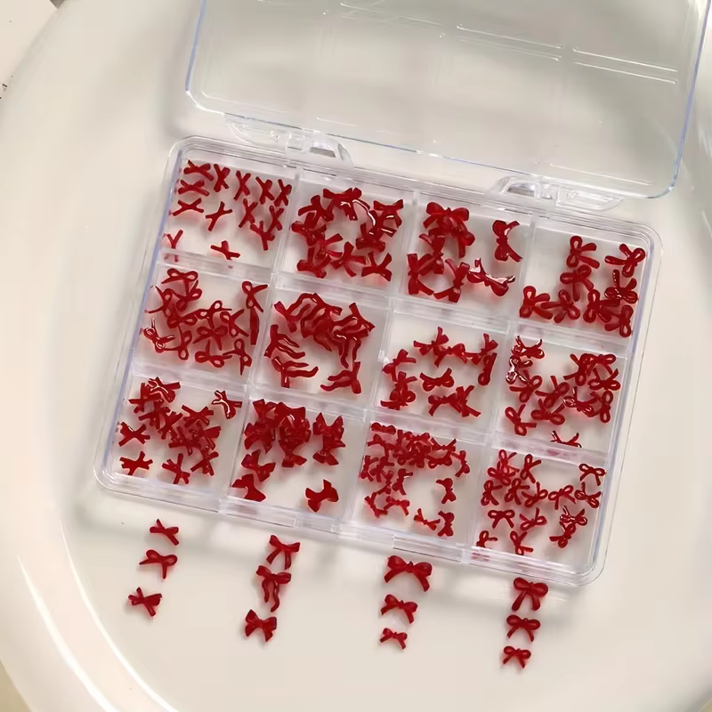 Une boîte de 12 accessoires d'art d'ongle à nœud coloré et doux