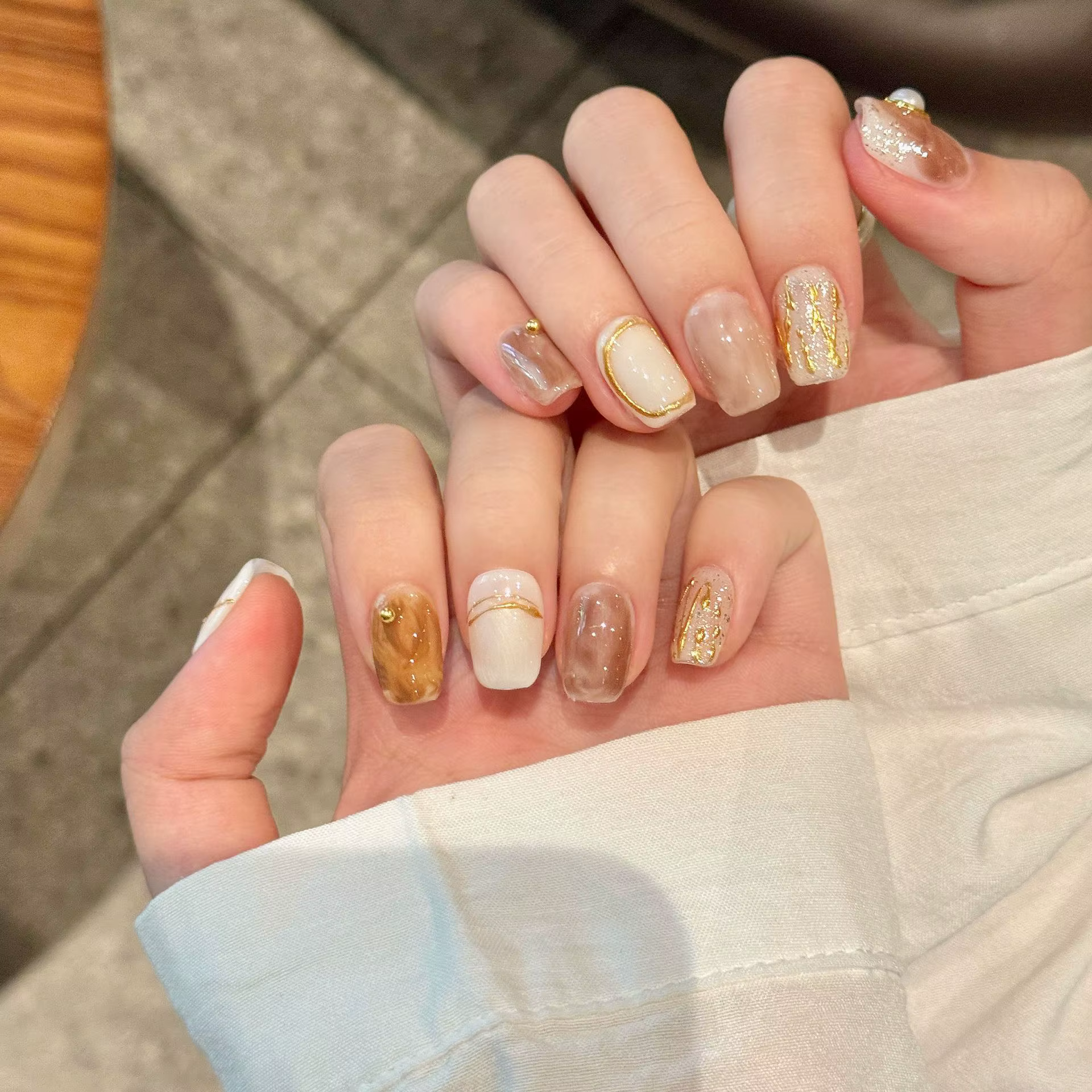 Presse à la main sur les ongles paillettes blanc perle décor faux